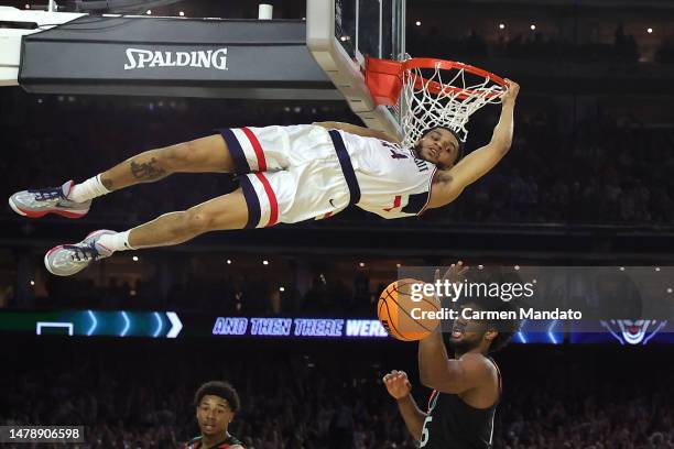 Andre Jackson Jr. #44 of the Connecticut Huskies hangs on to the rim after dunking the ball during the second half against the Miami Hurricanes...