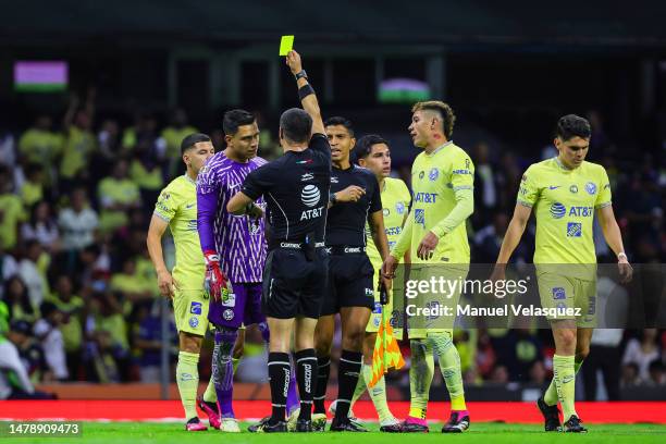 Fernando Hernandez referee shows the yellow card to Luis Malagón of America during the 13th round match between America and Leon as part of the...