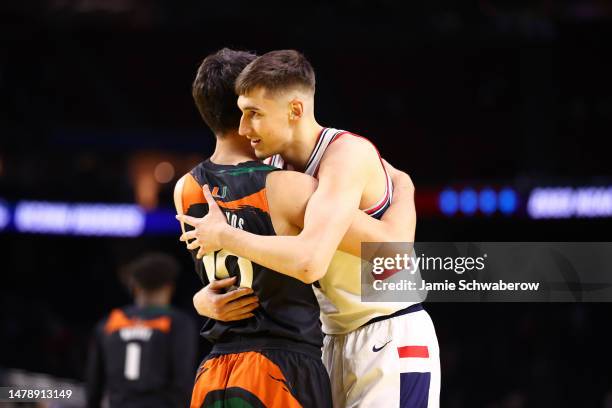 Filippos Gkogkos of the Miami Hurricanes and Apostolos Roumoglou of the Connecticut Huskies hug at the end of the NCAA Men’s Basketball Tournament...