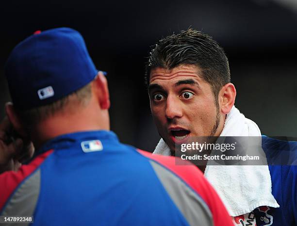 Matt Garza of the Chicago Cubs has a discussion with Pitching Coach Chris Bosio after the first inning of the game against the Atlanta Braves at...