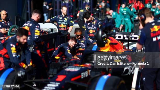 The Red Bull Racing team work on the car of Max Verstappen of the Netherlands and Oracle Red Bull Racing in the Pitlane during the red flag delay...