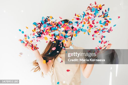 Woman celebrating with confetti on white background. Woman celebrating with confetti on white background.