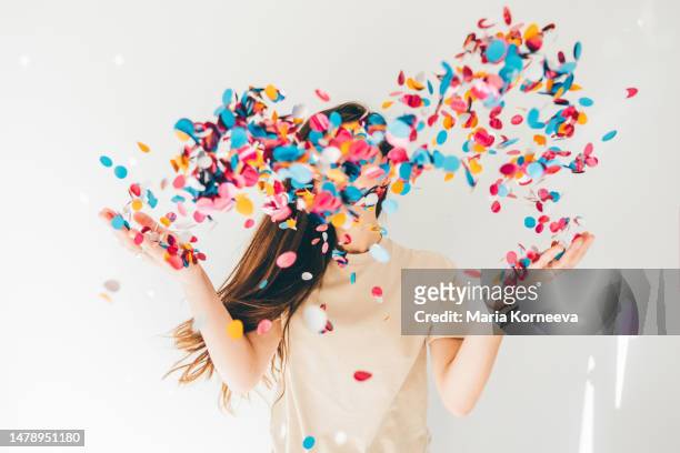 woman celebrating with confetti on white background. - congratulations winner stock pictures, royalty-free photos & images