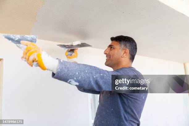 worker plastering with tool plaster - gypsum stock pictures, royalty-free photos & images