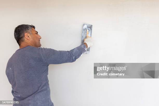 worker plastering with tool plaster - gypsum stock pictures, royalty-free photos & images