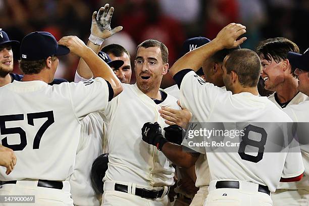 Adam LaRoche of the Washington Nationals is mobbed by teammates after driving in the winning run to beat the San Francisco Giants 6-5 during the...