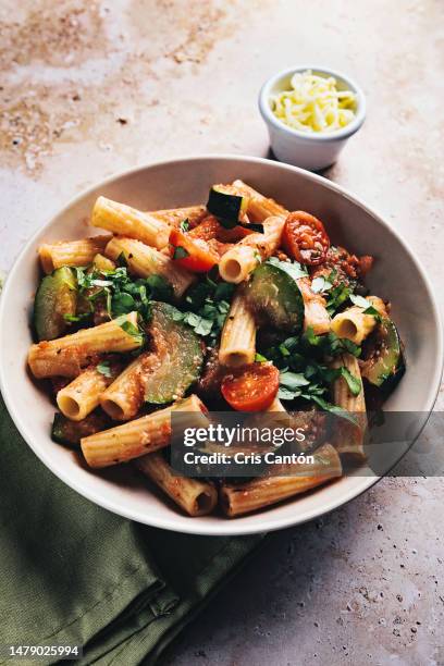 rigatoni with zucchini and tomato sauce - rigatoni stock-fotos und bilder