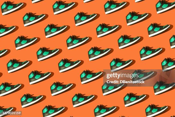 pattern of black and green basketball sneakers, on a orange background. concept for sneaker, basketball, retro, fashion, collection and casual - orange shoe ストックフォトと画像