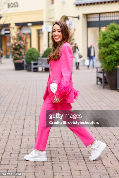 Simone Elbing, wearing a pink suit by Zara, white sneakers by Alexander McQueen and a white heart-shaped bag by Chanel, during a streetstyle shooting...