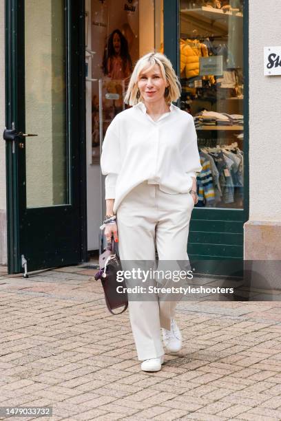 Influencer Simone Adams, wearing a white oversize blouse by Seidensticker x Bettina Zimmermann, beige pants by TRVL DRSS, white sneakers by Juvia,...