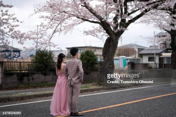 Couple poses for a wedding photograph near cherry trees in bloom in the Yonomori area on April 02, 2023 in Tomioka, Fukushima, Japan. The evacuation...