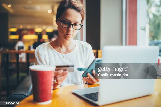woman in cafe making online payments - phishing stock pictures, royalty-free photos & images