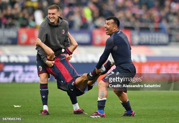 Michel Aebischer and Gary Medel of Bologna FC interact with teammate Nicolas Dominguez as they celebrate victory following the Serie A match between...