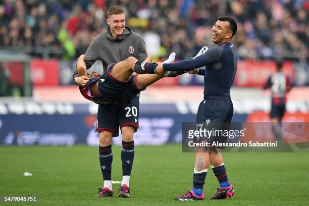 Michel Aebischer and Gary Medel of Bologna FC interact with teammate Nicolas Dominguez as they celebrate victory following the Serie A match between...