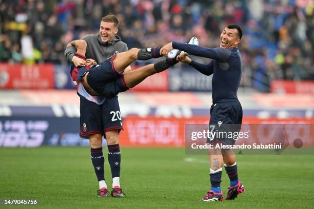 Michel Aebischer and Gary Medel of Bologna FC interact with teammate Nicolas Dominguez as they celebrate victory following the Serie A match between...