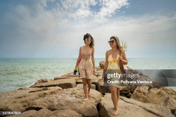 tourists walking on the rocks of the tropical beach - family algarve stock pictures, royalty-free photos & images