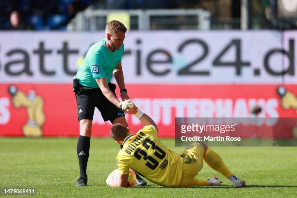 Referee, Timo Gerach helps up Martin Fraisl of DSC Arminia Bielefeld during the Second Bundesliga match between Holstein Kiel and DSC Arminia...