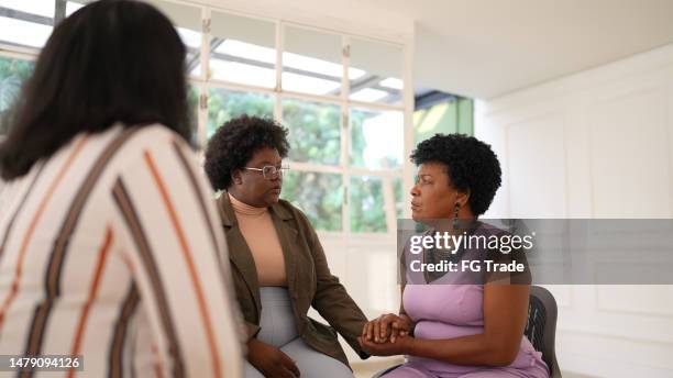 mature woman giving support on a group therapy - president bush speaks on death of justice rehnquist stockfoto's en -beelden