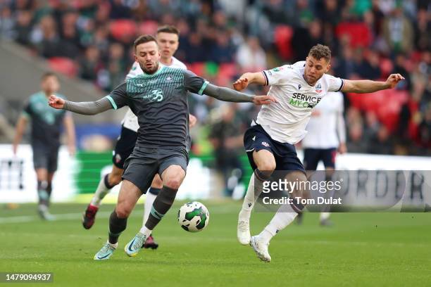 Matt Butcher of Plymouth Argyle battles for possession with Dion Charles of Bolton Wanderers during the Papa John's Trophy Final between Bolton...