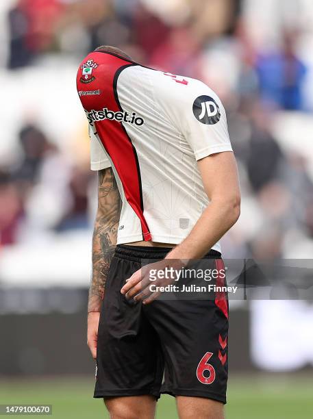 Dejected Duje Caleta-Car of Southampton wears his shirt over his head at full time during the Premier League match between West Ham United and...