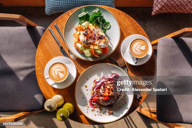 brunch with sweet pancakes and eggs benedict with salmon served in restaurant - lunch london stock pictures, royalty-free photos & images