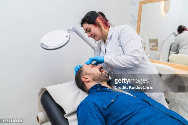trichologist specialist checking the scalp of a patient with baldness - doctor looking down stock pictures, royalty-free photos & images