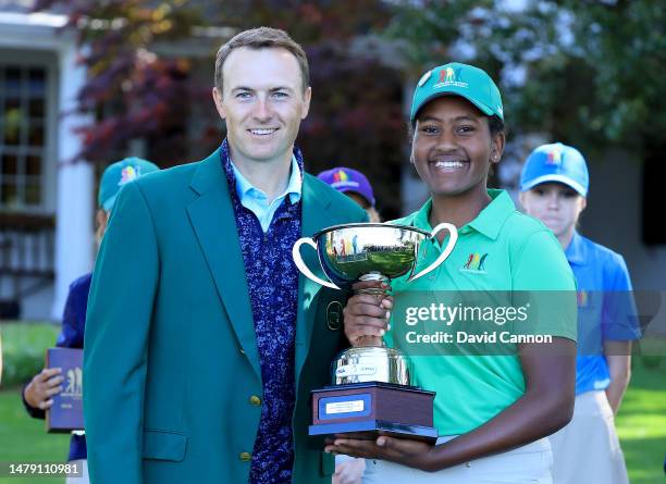 Maya Palanza Gaudin of The United States is presented with the Girls 12-13 year group overall champion trophy by Jordan Spieth of The United States...