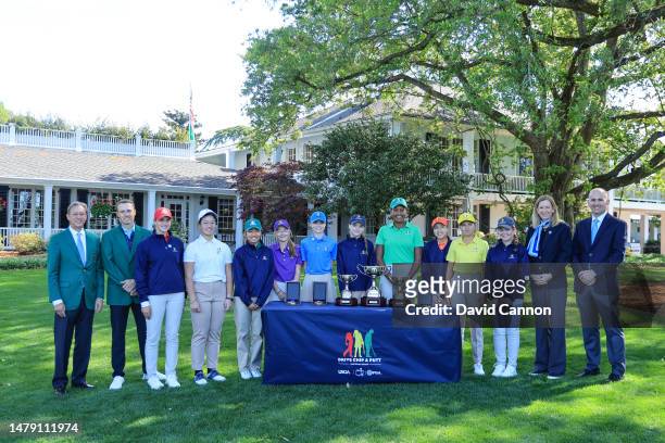 Maya Palanza Gaudin of The United States the Girls 12-13 year group overall champion poses with her trophy and her fellow competitors and officials...