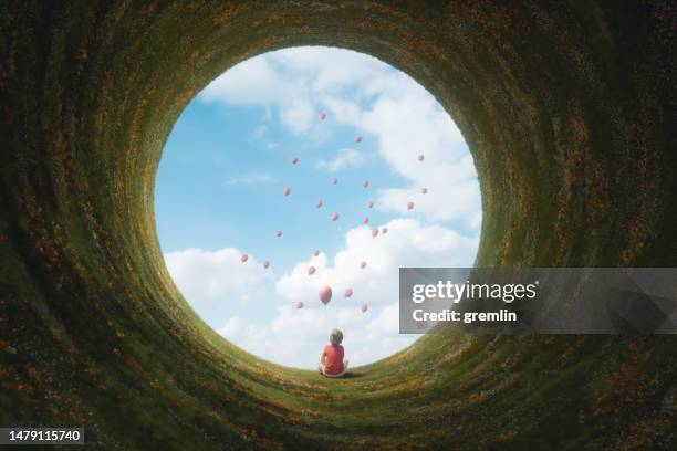 young boy sitting in fantasy landscape - childhood dream stock pictures, royalty-free photos & images