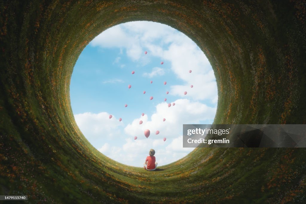 Menino novo sentado na paisagem da fantasia