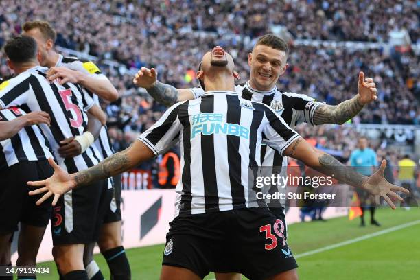 Bruno Guimaraes of Newcastle United celebrates with teammate Keiran Trippier after Joe Willock scores the teams first goal during the Premier League...