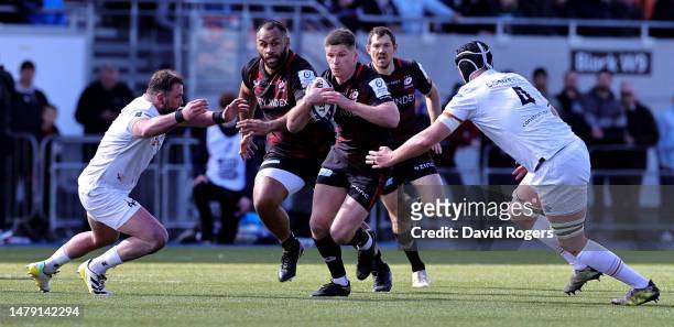 Owen Farrell of Saracens is tackled by Sam Parry and Adam Beard during the Heineken Champions Cup match between Saracens and Ospreys at the StoneX...