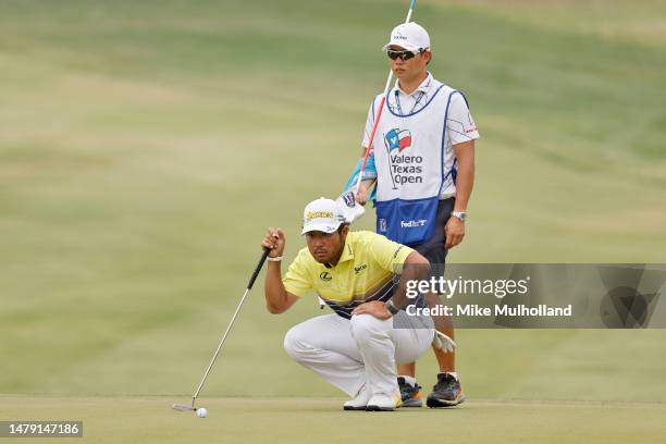 Hideki Matsuyama of Japan and his caddie line up a putt on the 10th green during the final round of the Valero Texas Open at TPC San Antonio on April...