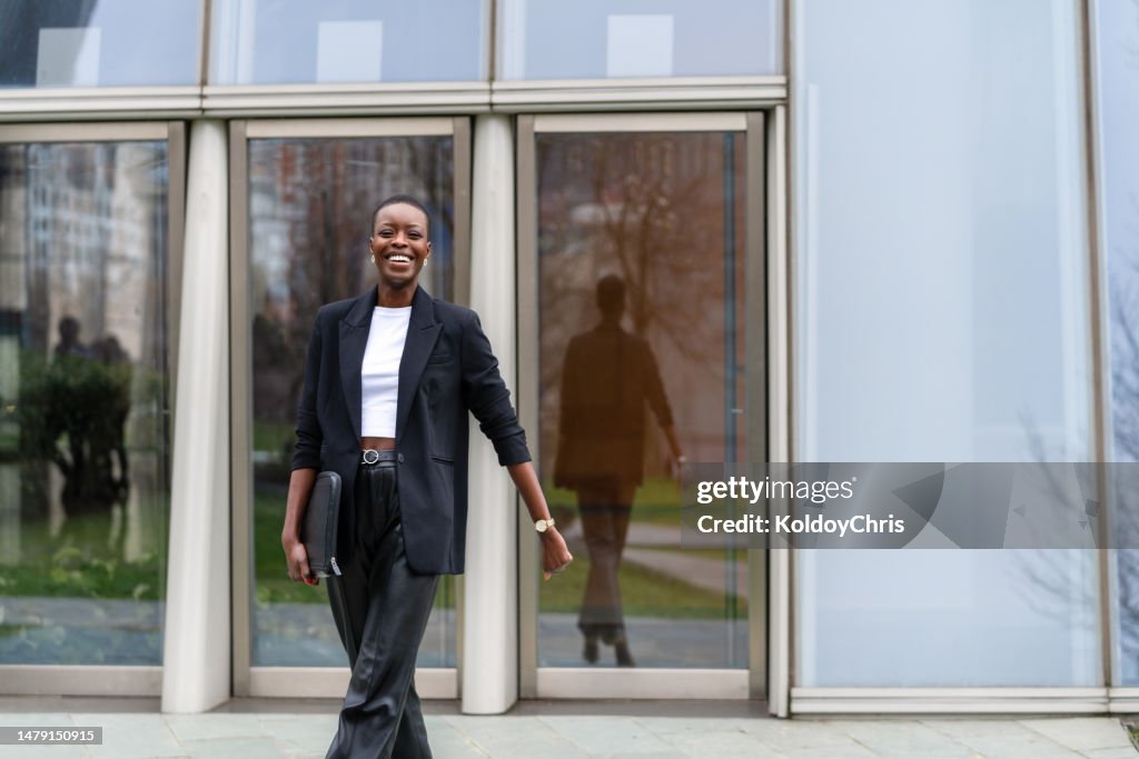 Portrait of a woman smiling outside a glass building