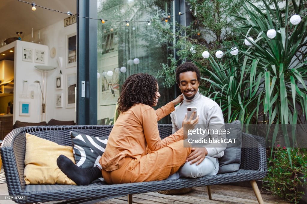 Happy young African American couple using smart phone