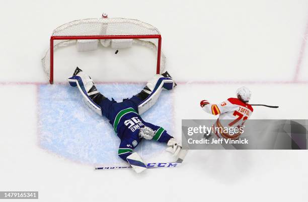 Tyler Toffoli of the Calgary Flames scores on Thatcher Demko of the Vancouver Canucks in overtime during their NHL game at Rogers Arena March 31,...