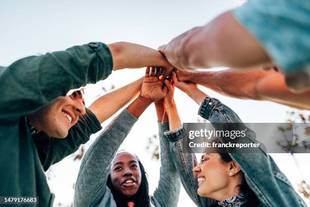 friends teamworking together - community arm in arm stock pictures, royalty-free photos & images