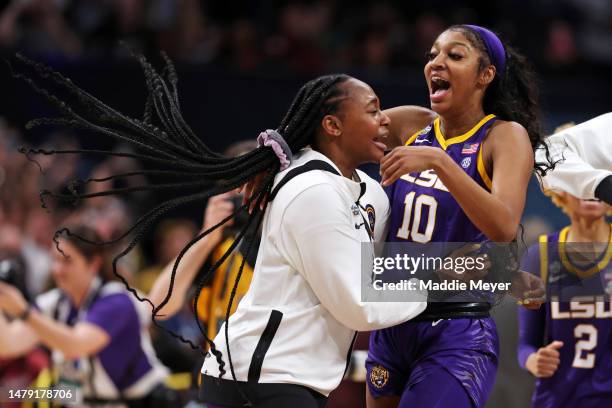 Angel Reese of the LSU Lady Tigers celebrates with a teammate after defeating the Iowa Hawkeyes 102-85 during the 2023 NCAA Women's Basketball...