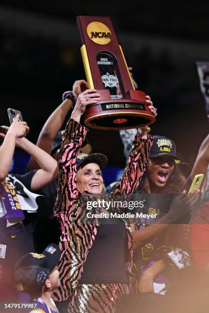 Head coach Kim Mulkey of the LSU Lady Tigers holds the championship trophy after defeating the Iowa Hawkeyes 102-85 during the 2023 NCAA Women's...