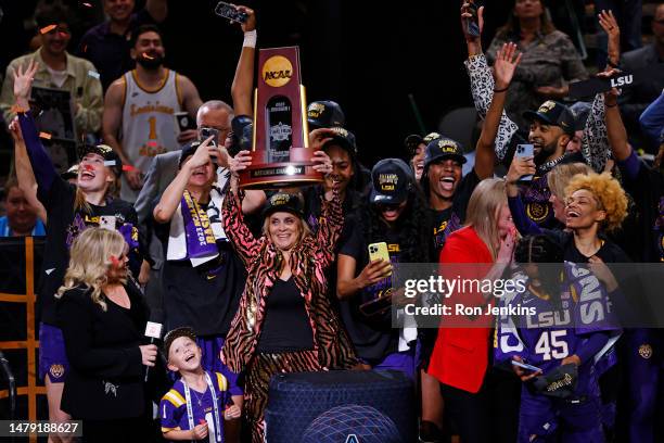 Head coach Kim Mulkey of the LSU Lady Tigers holds the championship trophy after defeating the Iowa Hawkeyes 102-85 during the 2023 NCAA Women's...