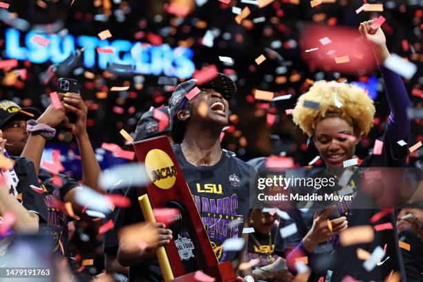 Flau'jae Johnson of the LSU Lady Tigers reacts while holding the championship trophy after defeating the Iowa Hawkeyes 102-85 during the 2023 NCAA...