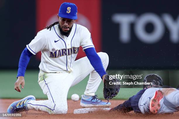 Myles Straw of the Cleveland Guardians steals second base against J.P. Crawford of the Seattle Mariners during the ninth inning at T-Mobile Park on...