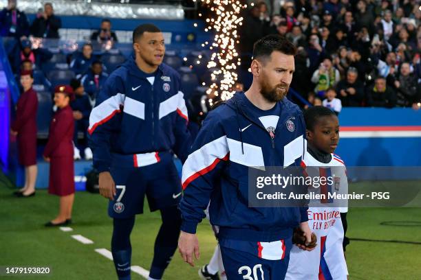 Kylian Mbappe and Leo Messi of Paris Saint Germain walk on the pitch before the Ligue 1 match between Paris Saint-Germain and Olympique Lyon at Parc...