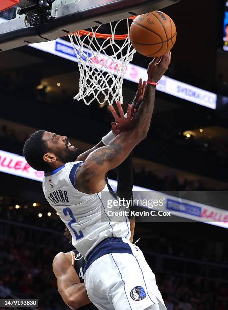 Kyrie Irving of the Dallas Mavericks draws a foul as he drives against Jalen Johnson of the Atlanta Hawks during the second quarter at State Farm...