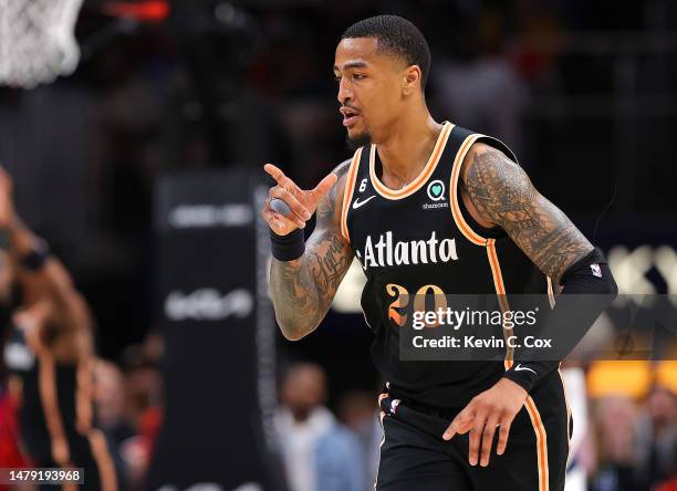 John Collins of the Atlanta Hawks reacts after shooting a three-point basket against the Dallas Mavericks during the second quarter at State Farm...