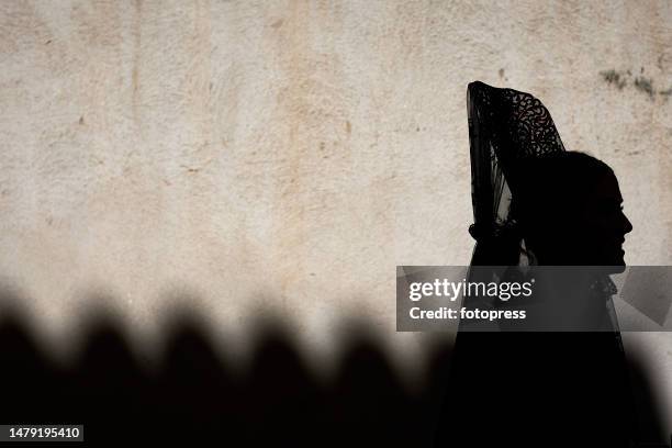 Woman wearing a traditional ‘Mantilla’ looks on in the Entrada de Jesus en Jerusalen brotherhood procession during the Palm Sunday of Holy Week on...