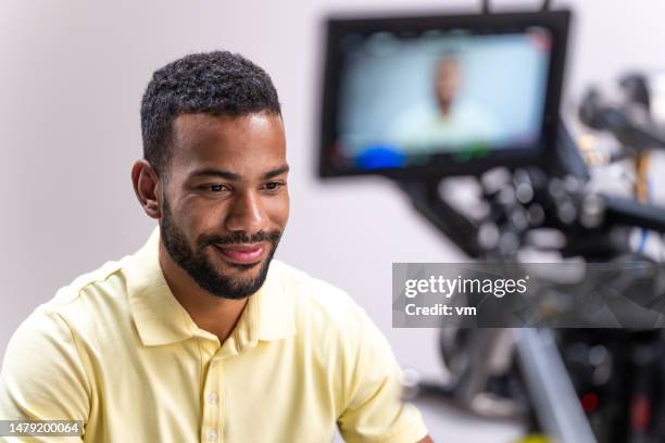 smiling man giving interview on camera - videoshoot stockfoto's en -beelden