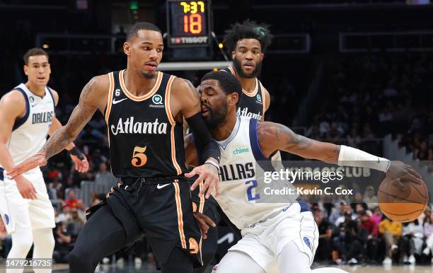 Kyrie Irving of the Dallas Mavericks drives into Dejounte Murray of the Atlanta Hawks during the first quarter at State Farm Arena on April 02, 2023...