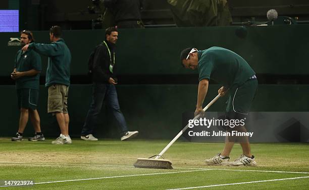 Groundsman sweeps the baseline on centre court after day six of the Wimbledon Lawn Tennis Championships at the All England Lawn Tennis and Croquet...