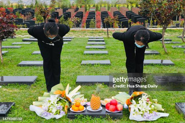 Staff members of a funeral parlour pay tribute to a deceased on behalf of the relatives of the deceased ahead of Qingming Festival on March 31, 2023...